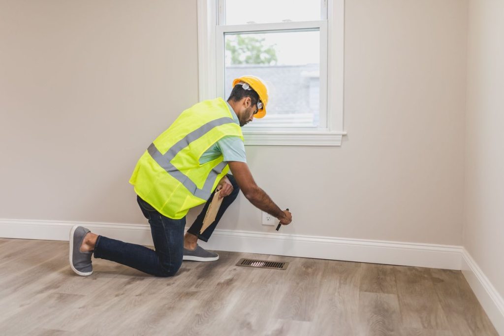A home interior inspection along a baseboard and floor vent